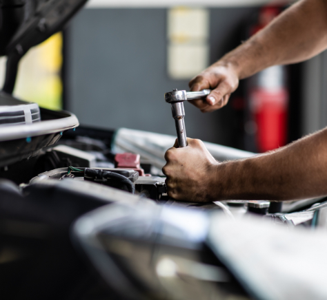 male mechanic repairs car